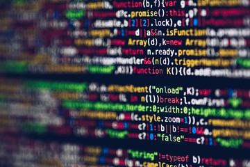 Close-up of colourful programming code on a dark screen